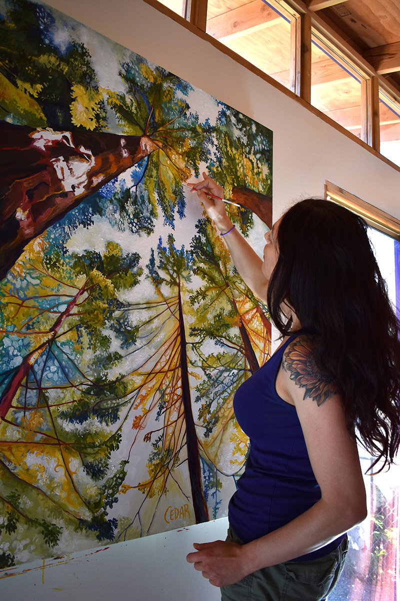 Cedar Lee working in the studio. Painting: "Sun-Dappled Sequoias"