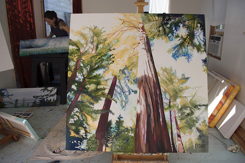 Cedar Lee artist working in the studio. Foreground: Suffused With Light. 48" x 48", Oil on Wood, © 2017 Cedar Lee