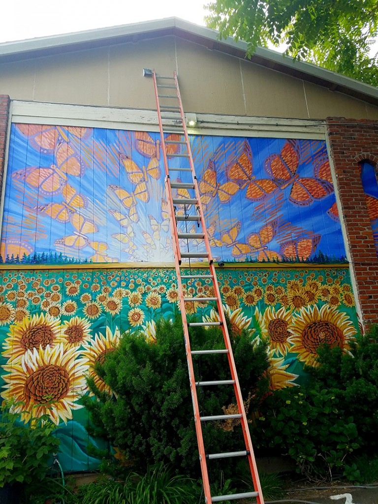 Cedar Lee assisting in installation of Hector Hernandez Monarca Mural in Portland, OR