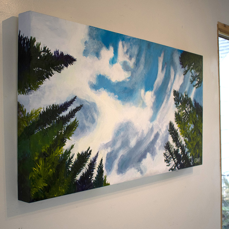 Painting by Cedar Lee of clouds floating in a blue sky over evergreen trees.
