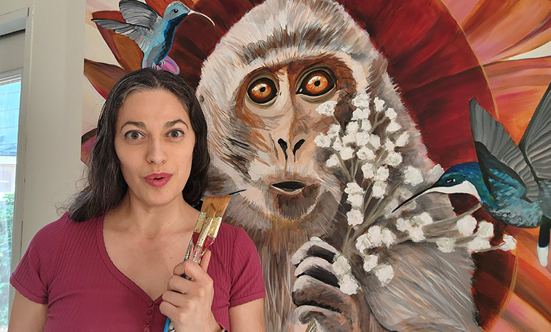 Artist Cedar Lee with painting of a monkey titled The Jester